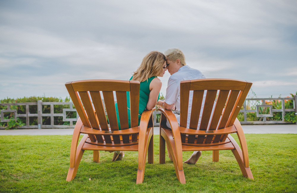 loving couple, touching their foreheads, intimate moment, sitting on Adirondack chairs